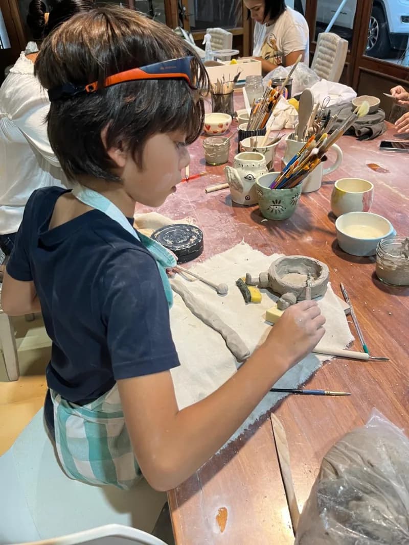 Kid sculpting clay in workshop